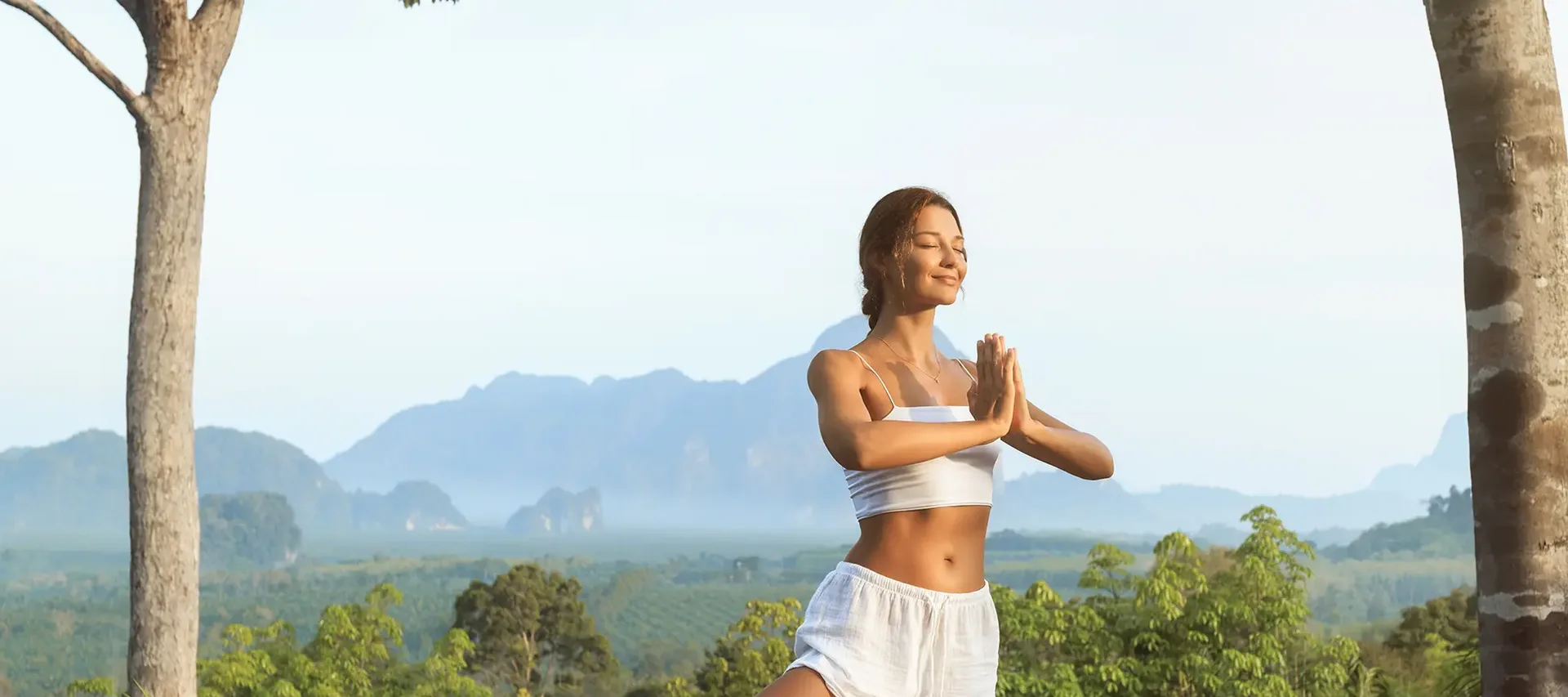 Yoga im Dschungel mit Bergpanorama Yoga-Pose im tropischen Dschungel mit Bergen im Hintergrund