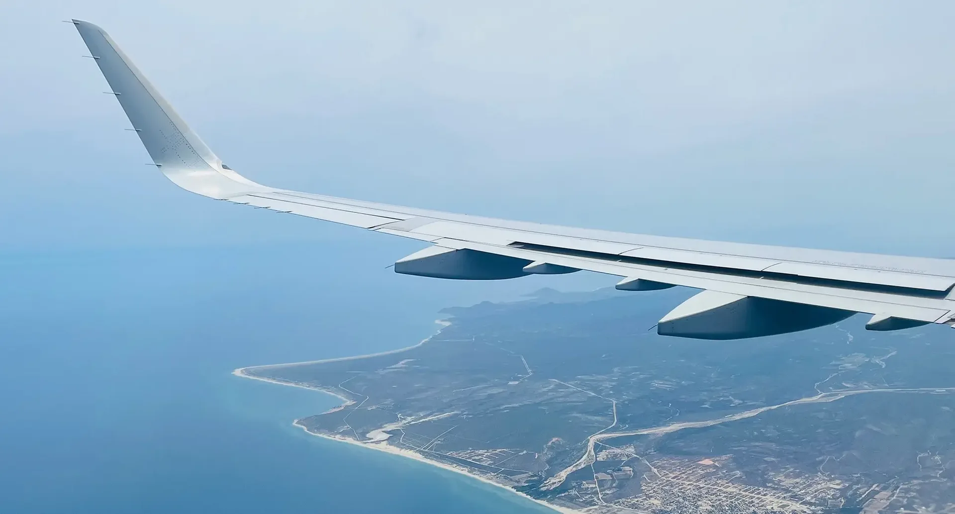 Blick aus dem fliegenden Flugzeug auf eine Insel