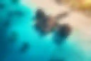 Strandresort auf Sansibar mit Holzbungalows auf Stelzen über türkisblauem Meer und Steg zum Sandstrand