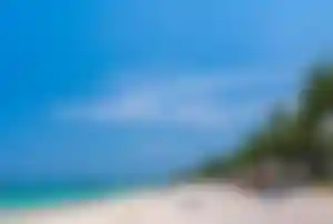 Strand von Trou aux Biches mit weißem Sand, türkisfarbenem Meer und Palmen auf Mauritius. Bildtitel: