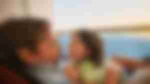 Familienzeit und Entspannung an Bord der AIDAcosma Elternteil und Kind entspannen gemeinsam an Bord eines Kreuzfahrtschiffs mit Meerblick