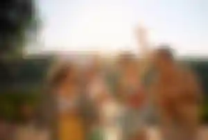 Gruppe junger Freunde feiert im Partyurlaub im Freien mit Cocktails, Musik und sommerlicher Atmosphäre