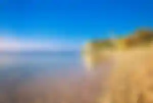 Kiesstrand mit klarem Wasser und Kirche an der Küste auf der Insel Brač Kroatien