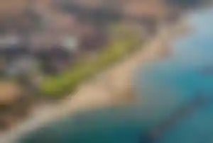 Robinson Cyprus Strandhotel – hochwertige Zypern Hotels mit direkter Lage am Meer Strand und Hotelanlage des Robinson Cyprus aus der Luft mit direkter Strandlage, Liegen und weitläufiger Resortanlage