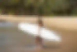Surferin mit weißem Board am Strand von Sri Lanka