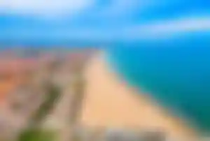 Panoramablick auf den breiten Sandstrand und die Küstenlinie von Valencia mit klarem blauen Meer.“