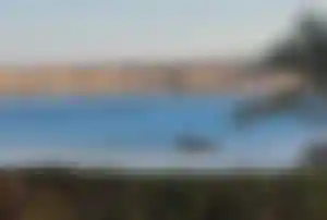 Ruhige Bucht in Hurghada mit klarem Wasser, kleinem Boot und Wüstenlandschaft im Hintergrund – ideal für Badeurlaub in Ägypten