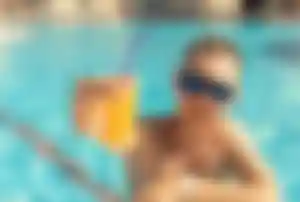 Mann in Pool zeigt seinen Orangensaft