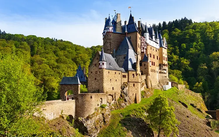 Burg Eltz inmitten grüner Wälder bei Sonnenschein